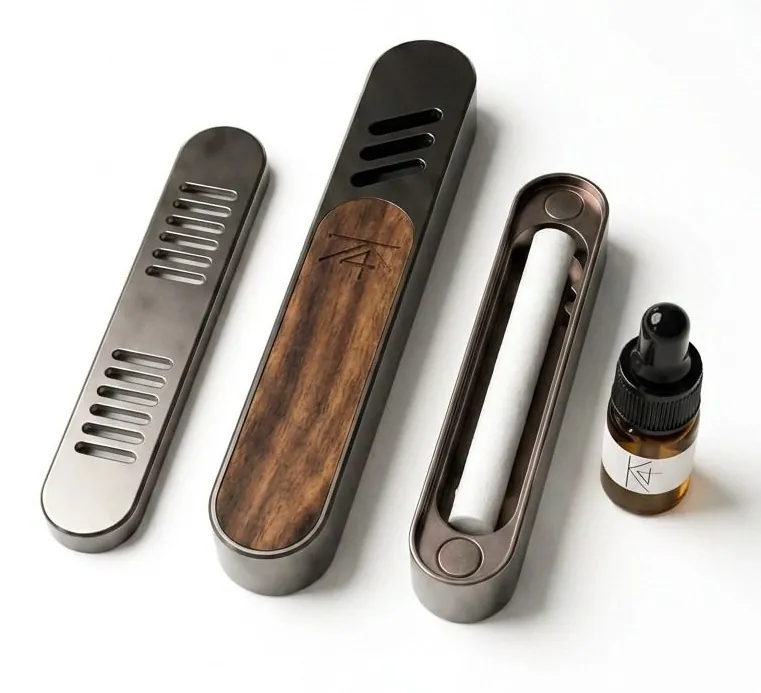 K4KAILASA vent-clip diffuser components: metal housing, walnut insert, fragrance pad, and refill oil bottle